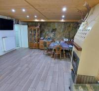 Eine geräumige Küche mit Holzbalkendecke, Kamin und Esstisch in einem Einfamilienhaus.