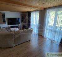 Wohnzimmer in einem Einfamilienhaus mit großem Fernseher und bequemer Couch.