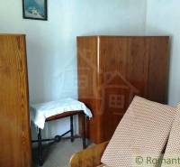 Holzschränke und ein Sofa im Zimmer eines Einfamilienhauses.