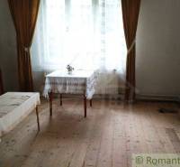 Wohnzimmer eines Einfamilienhauses mit antiken Möbeln und Holzboden.