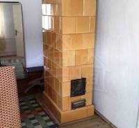 Kachelofen, Holzboden, Spiegel, Teppich im Einfamilienhaus.