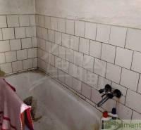 Ein Badezimmer mit einer gefliesten Badewanne in einem Einfamilienhaus.