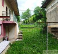 Ein Einfamilienhaus in Fričovce mit einem ungepflegten Garten, neben vernachlässigten Fassaden und einer Treppe.
