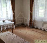 Innenraum eines Einfamilienhauses mit Holzboden, Tisch und langen Vorhängen.