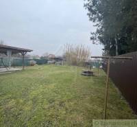 Ein Garten mit Rasen bei einem Einfamilienhaus, ein Pavillon und eine Wäscheleine, ein Holzzaun.