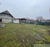 Ein Einfamilienhaus mit Garten und Brunnen in einer ruhigen ländlichen Gegend.