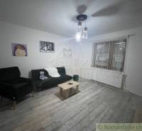 Wohnzimmer in einem Einfamilienhaus mit Sessel, Sofa, Couchtisch und Bildern an den Wänden.