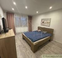 Schlafzimmer mit Doppelbett, Fernseher und Bild, Teil eines Einfamilienhauses.