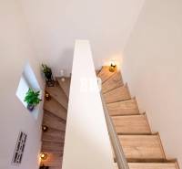 Die Treppe des Einfamilienhauses mit Blumen, Kerzen und Holzstufen.