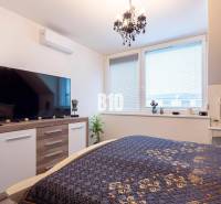 Schlafzimmer in einem Einfamilienhaus mit großem Fernseher und elegantem Kronleuchter.