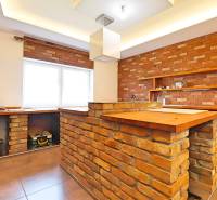 Küche in einem Einfamilienhaus mit Ziegelwänden und einer Holztheke.
