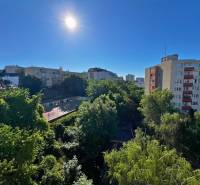 Sonniger Blick auf Grünflächen und Gebäude von einer 2-Zimmer-Wohnung in der Ladzianskeho Straße in Bratislava.