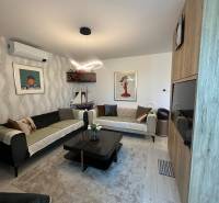 Wohnzimmer in einem Einfamilienhaus mit Sofas, Dekorationen und Bildern an den Wänden.