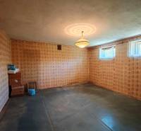 Ein Zimmer in einem Einfamilienhaus mit Vintage-Tapeten, einem Kronleuchter und kleinen Fenstern.