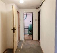 Flur im Einfamilienhaus mit Zugang zum Technikraum, einfache Wände und Boden.