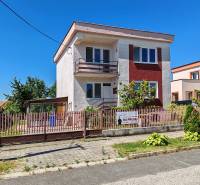 Ein Einfamilienhaus in der Školská-Straße in Voderady mit einem eingezäunten Garten und einem Pavillon.