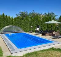 Ein Pool mit Überdachung, Gartenmöbel und Sonnenschirm bei einem Einfamilienhaus in Trenčianske Jastrabie.