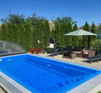 Ein Pool mit Gartenmöbeln und Liegestühlen in einem Einfamilienhaus in Trenčianske Jastrabie.