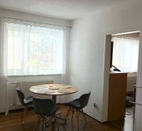 Esszimmer in einem Einfamilienhaus mit Fenster, Tisch und vier Stühlen, weißen Wänden.