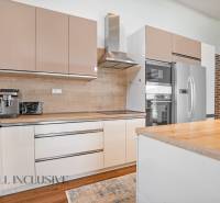 Moderne Küche in einem Einfamilienhaus mit einer Arbeitsplatte aus Holz und Geräten.