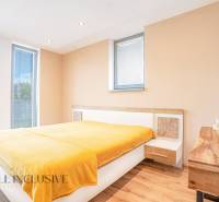 Helles Schlafzimmer mit Holzboden und gelber Decke in einem Einfamilienhaus.
