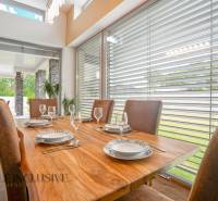 Esszimmer in einem Einfamilienhaus mit einem Holztisch, gedecktem Geschirr und Blick auf die Terrasse.