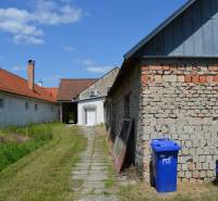 Geschäftsräume in Borský Svätý Jur, Gebäude mit rotem Dach, Rasen und blauer Container.