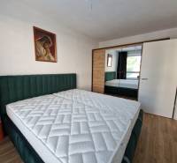 Schlafzimmer in einer 2-Zimmer-Wohnung mit Doppelbett, Gemälde und Einbauschrank.