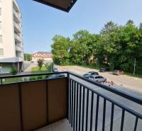 Blick vom Balkon auf die Straße Sadová in Senica, mit Aussicht auf den Parkplatz und das Grün.