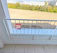 Der Balkon einer 2-Zimmer-Wohnung in der Labutej-Straße, Bratislava V mit Blick auf Grünflächen und Gebäude.