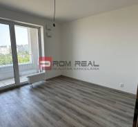 Ein leerer Raum mit Laminatboden und Glastüren in einer Zweizimmerwohnung.