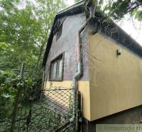 Ein Einfamilienhaus in Branč, umgeben von Grün mit einem Tor und einem Dachrinnensystem.