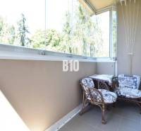 Ein verglaster Balkon mit zwei Stühlen in einer 3-Zimmer-Wohnung mit schönem Ausblick.