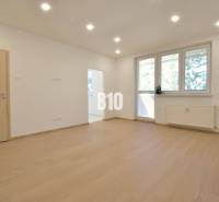 Helles Zimmer in einer 3-Zimmer-Wohnung mit Holzboden und großem Fenster.