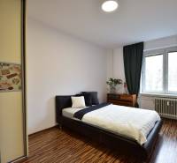 Schlafzimmer in einer 2-Zimmer-Wohnung mit Bett, Einbauschrank und Fenster.
