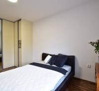 Schlafzimmer in einer 2-Zimmer-Wohnung mit Bett, Schrank und Holzkommode.