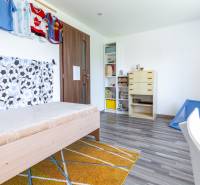 Kinderzimmer mit Bett, Schränken und Sporttrikots im Einfamilienhaus.