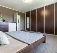 Schlafzimmer mit Bett, Schränke an der Wand, Kommode mit Dekorationen, Einfamilienhaus.
