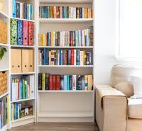Ein Bücherregal neben dem Sofa im Einfamilienhaus, ein heller Raum mit Holzboden.