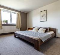 Schlafzimmer mit Holzbett, Wanddekoration und Fenster in einem Einfamilienhaus.