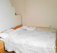 Helles Schlafzimmer mit Doppelbett in einer 2-Zimmer-Wohnung.