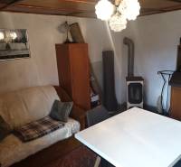 Wohnzimmer in einer Hütte mit Sofa, Tisch und Holzofen.