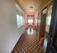 Ein langer Flur in einem Einfamilienhaus mit gemustertem Boden und Holzdecke.