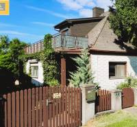 Ein Einfamilienhaus in Hundsheim mit einem Holzzaun, einer Terrasse und üppigem Grün.