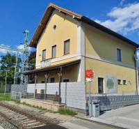 Das gelbe Bahnhofsgebäude in St. Andrä am Zicksee mit einem Hinweis auf die Züge.