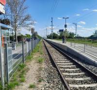 Bahnhof in St. Andrä am Zicksee mit Gleisen und einem Passagier auf dem Bahnsteig.