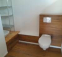 Badezimmer mit Toilette und Holzverkleidung in Geschäftsräumen.