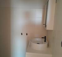 Badezimmergeschäftsräume mit Waschbecken und Schrank in neutralen Tönen.