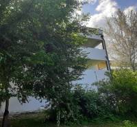 Eine Villa in Hainburg an der Donau, umgeben von Grün, mit teilweise freigelegten Stockwerken.