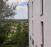 Die weiße Fassade der Villa in Hainburg an der Donau mit Blick auf den Garten und die Bäume.